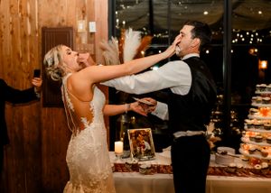 Couple enjoying first dance moment at rustic wooden venue with ambient lighting.
