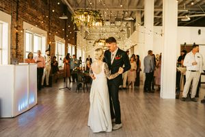 Wedding celebration in an industrial chic venue with exposed brick walls and white decor.