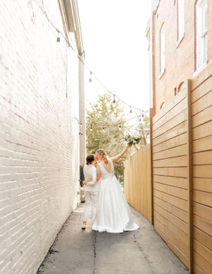 Wedding couple poses in a narrow brick alleyway creating artistic wedding portraits.