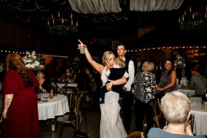 Wedding reception dance party in full swing with guests enjoying themselves under string lights.