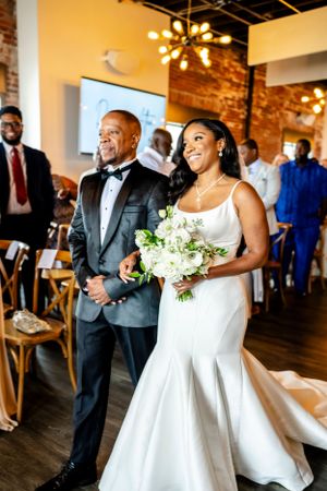 Wedding celebration inside a rustic brick-walled venue with warm lighting and hardwood floors.