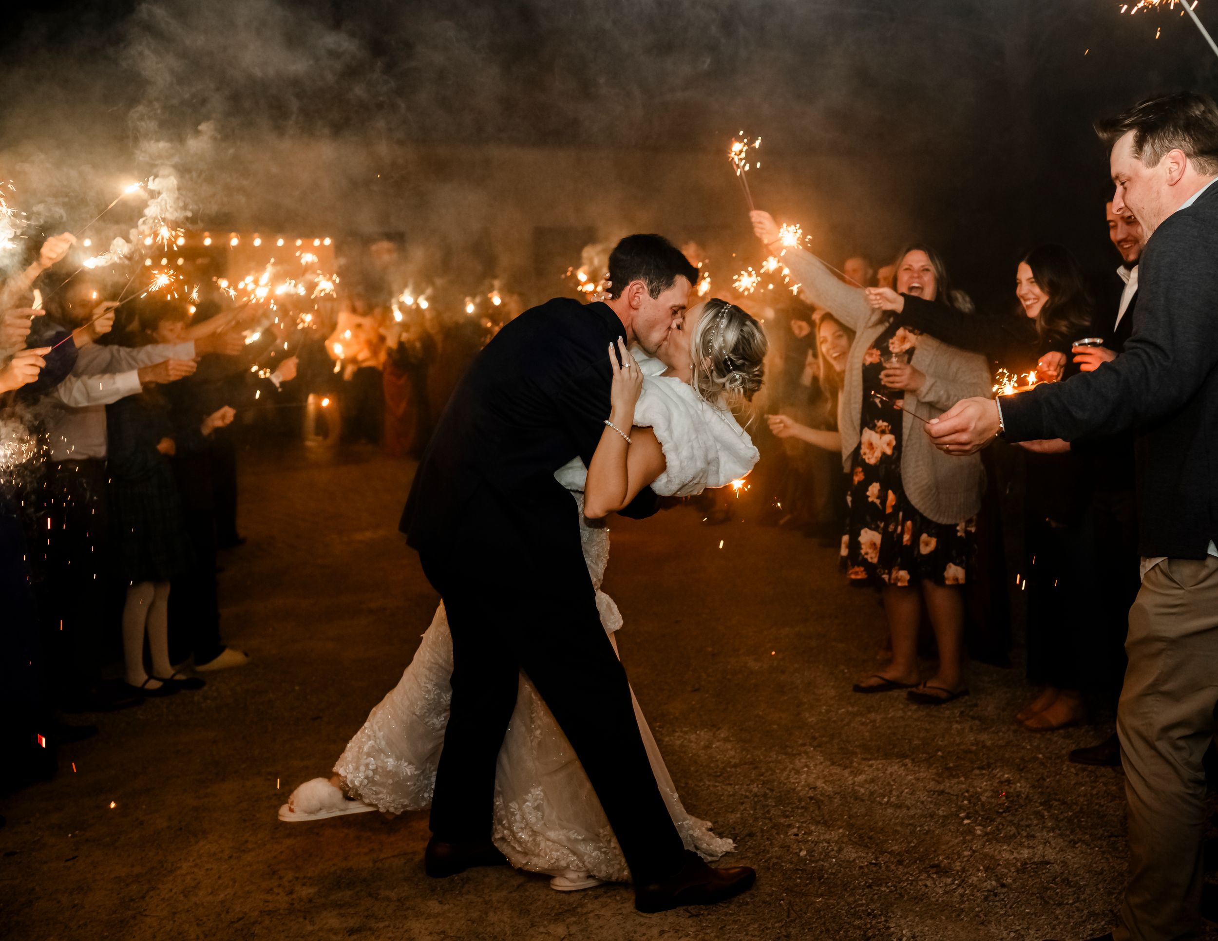 Sparklers light up the night as wedding guests create a magical exit pathway.