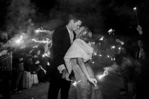 Sparklers create a magical nighttime atmosphere during a wedding celebration.