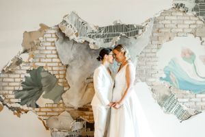 Artistic wedding photos captured against distressed painted brick walls.
