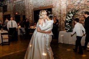 Wedding reception celebration in rustic brick venue with dancing and festivities.