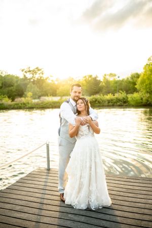 Romantic sunset photoshoot on a wooden dock by the water.
