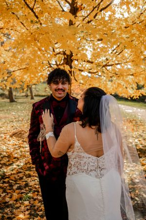 Wedding portraits captured under vibrant golden autumn trees.