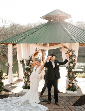 Intimate romantic moment captured between couple under rustic wooden pavilion.