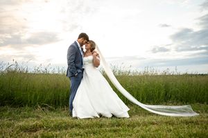 Romantic wedding portraits in a natural field setting during golden hour.