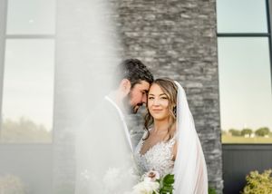 A romantic moment captured against a modern stone wall backdrop.