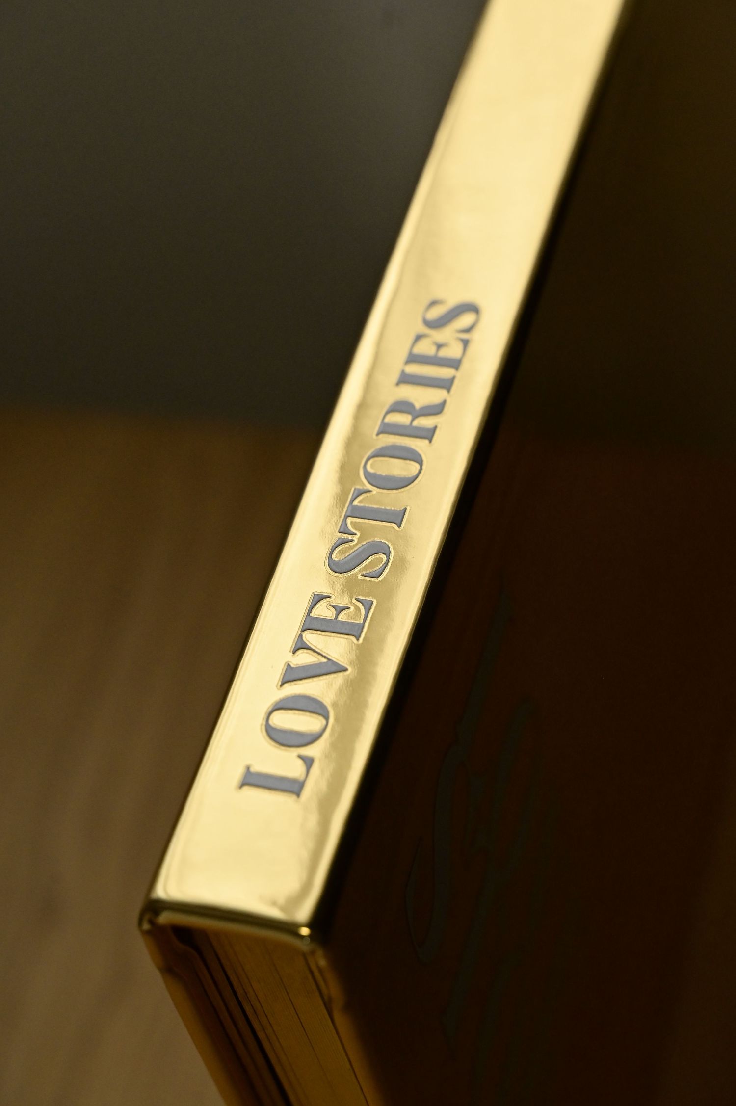 Gold spine of a luxury Love Stories hardcover book with embossed silver lettering.