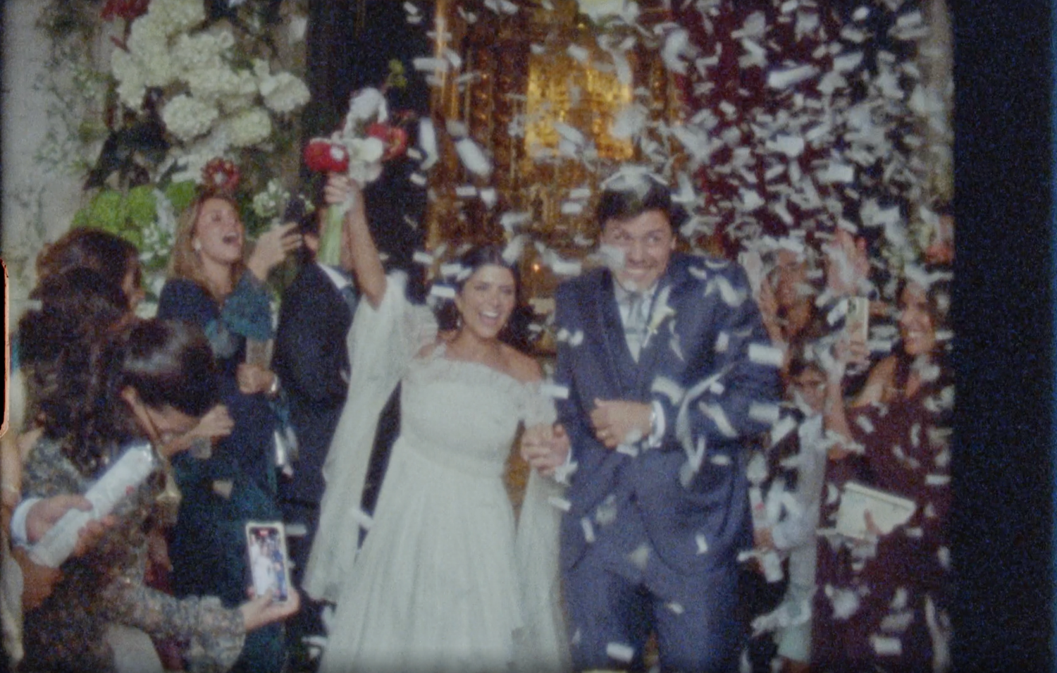 Maria and André wedding celebration on October 25, 2025, couple embracing surrounded by guests and floral decorations.