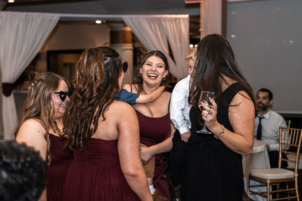 Women laughing and celebrating together at an elegant wedding reception venue.