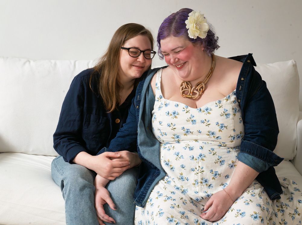 A female couple on a couch.