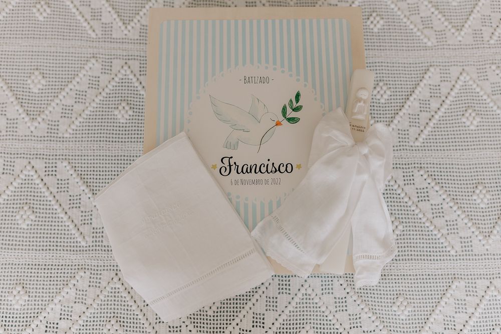 White baptism gift set with personalized Francisco box featuring a dove, folded cloth, and delicate fabric accessories on lace.