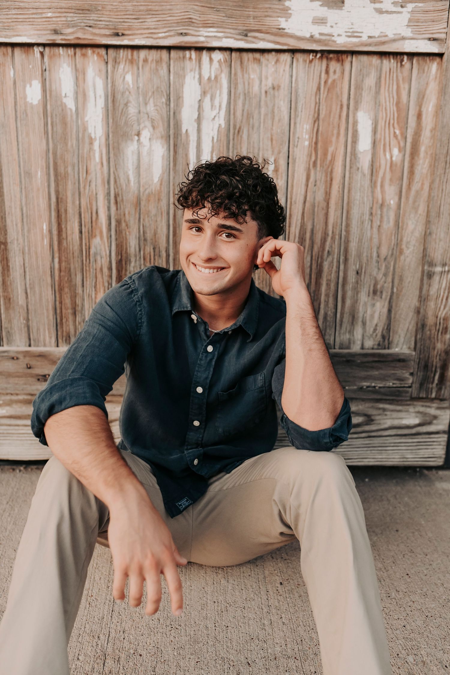High school senior guy standing against industrial brick walls at the Flour Mill in McKinney
