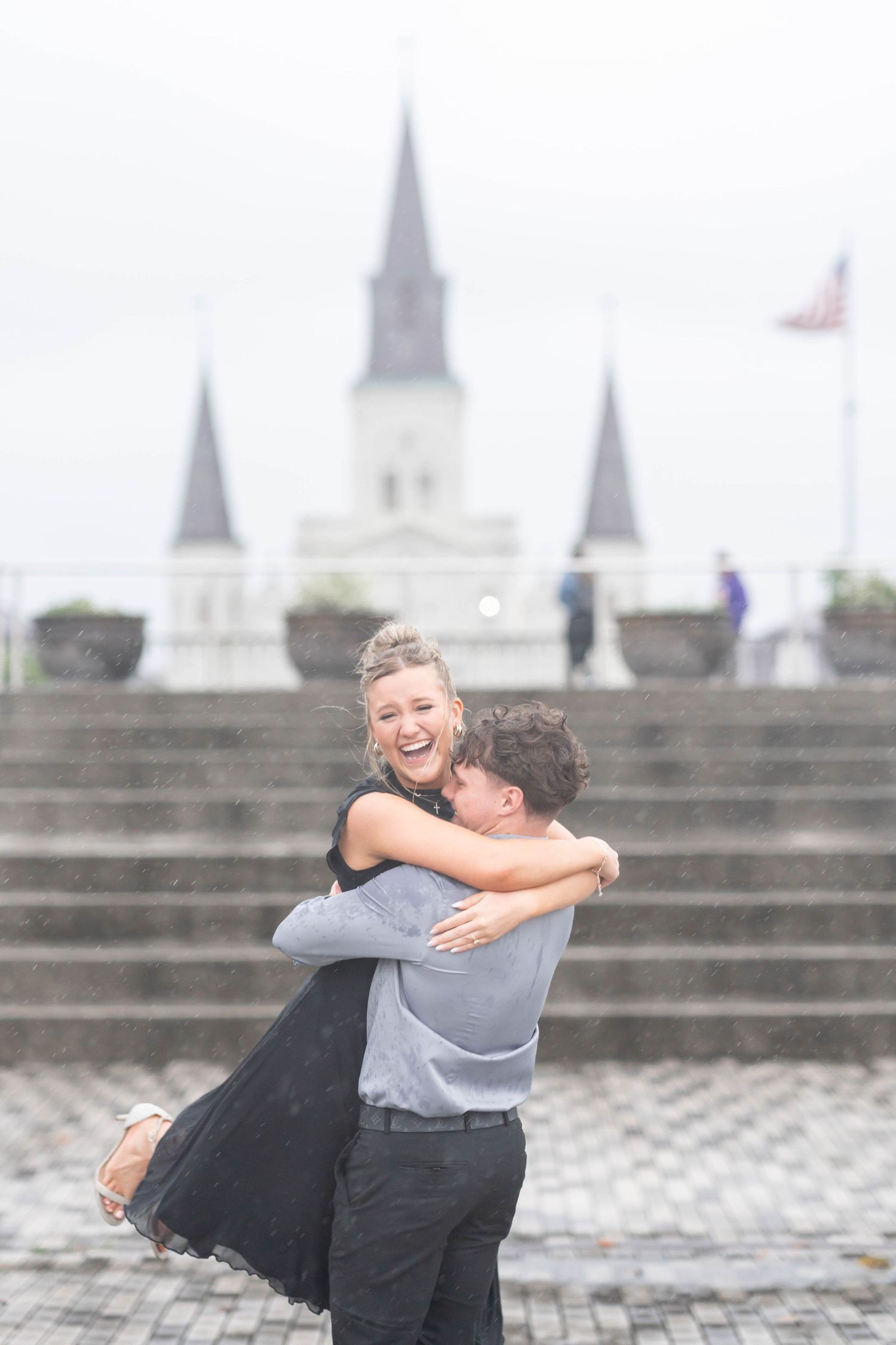 engaged couple plays in the rain
