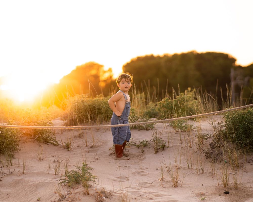 NIño durante una sesión de fotografía infantil familiar al atardecer en un entorno natural de Girona.