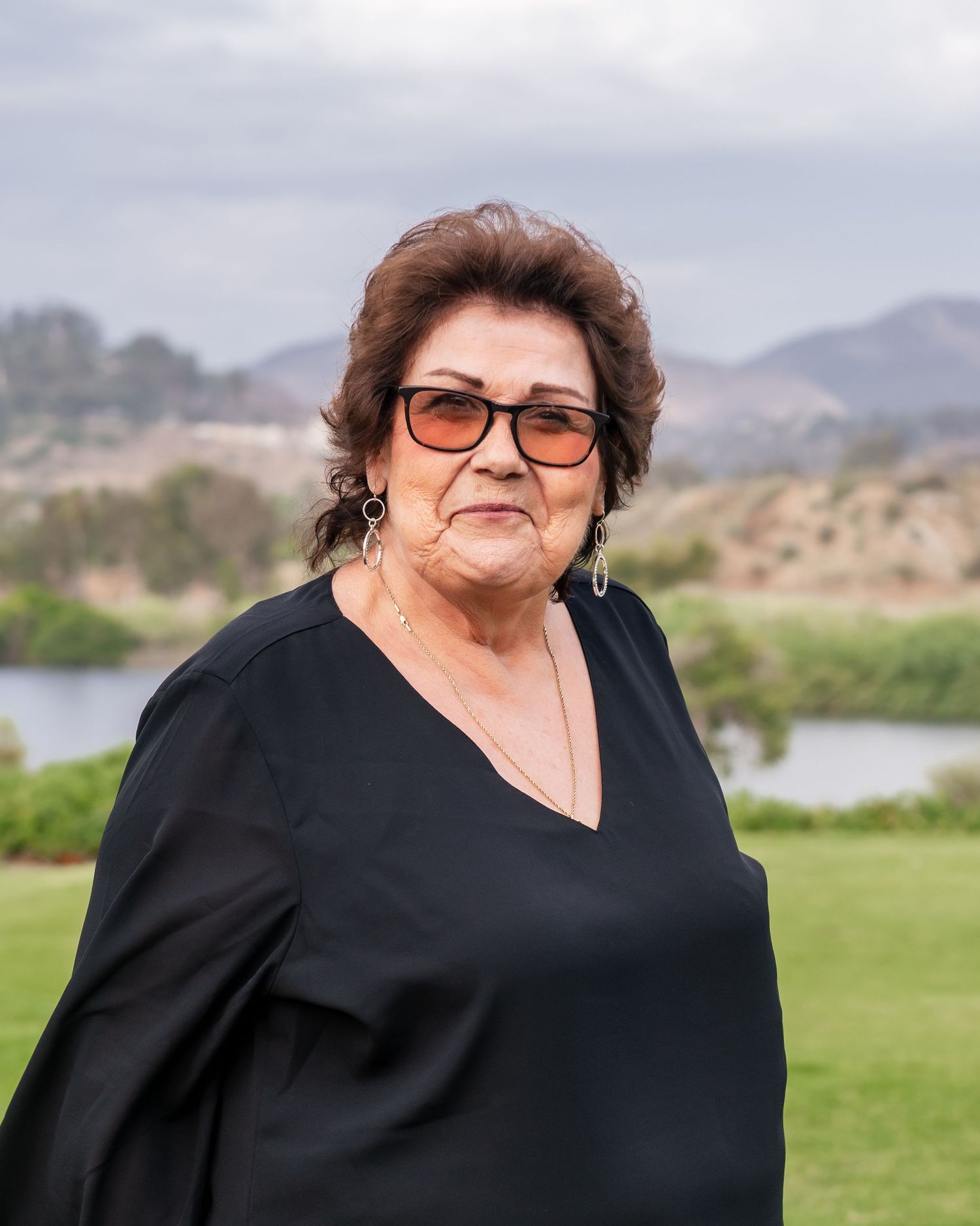 A series of outdoor portraits taken in a scenic natural setting with mountains and greenery in the background.