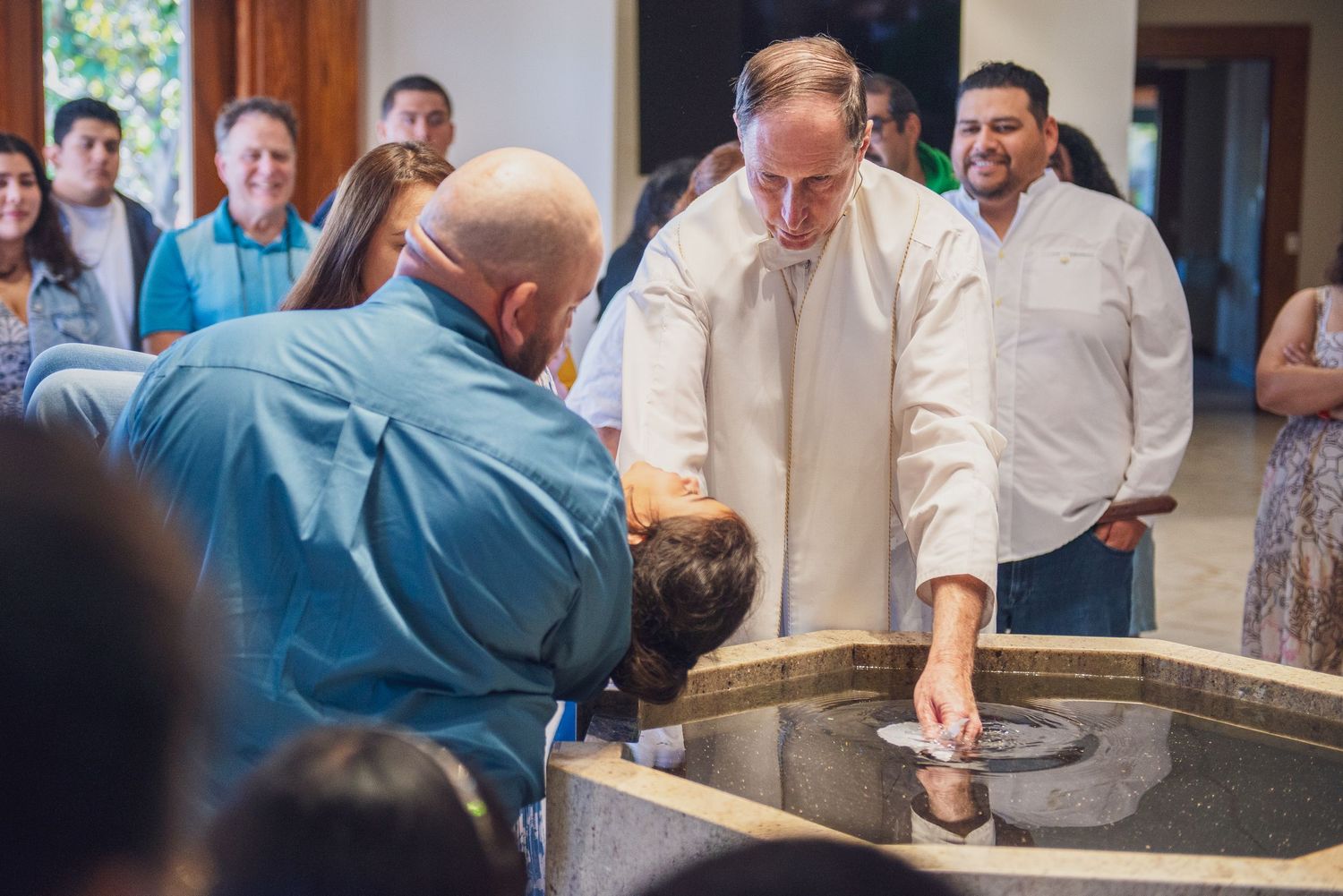 People gathered around a wooden bar or counter in what appears to be a social event or gathering space.