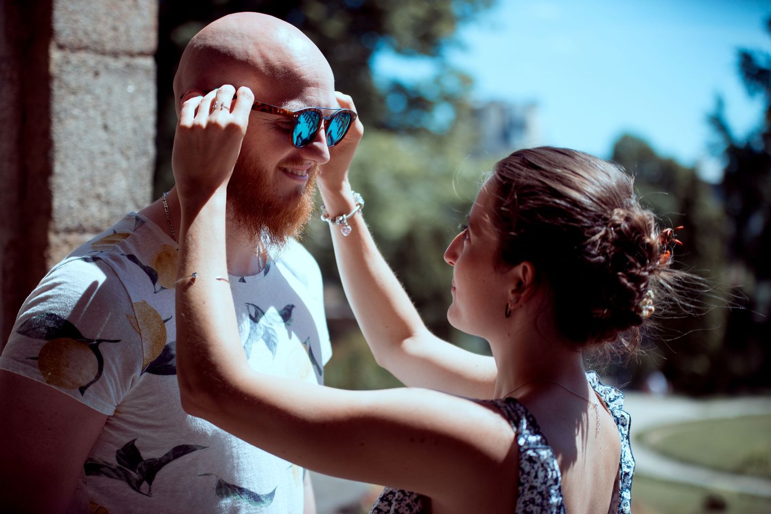 Couple complice profitant d’un moment ensoleillé en extérieur en Bretagne lors d’une séance engagement naturelle.