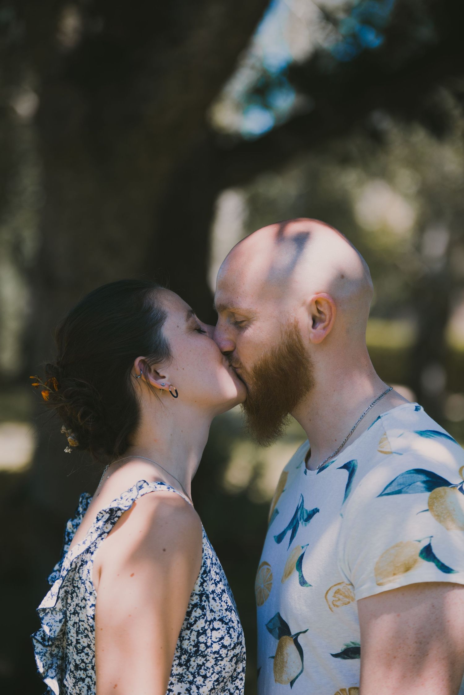 Couple s’embrassant dans un jardin en Bretagne, séance engagement intime en lumière naturelle.