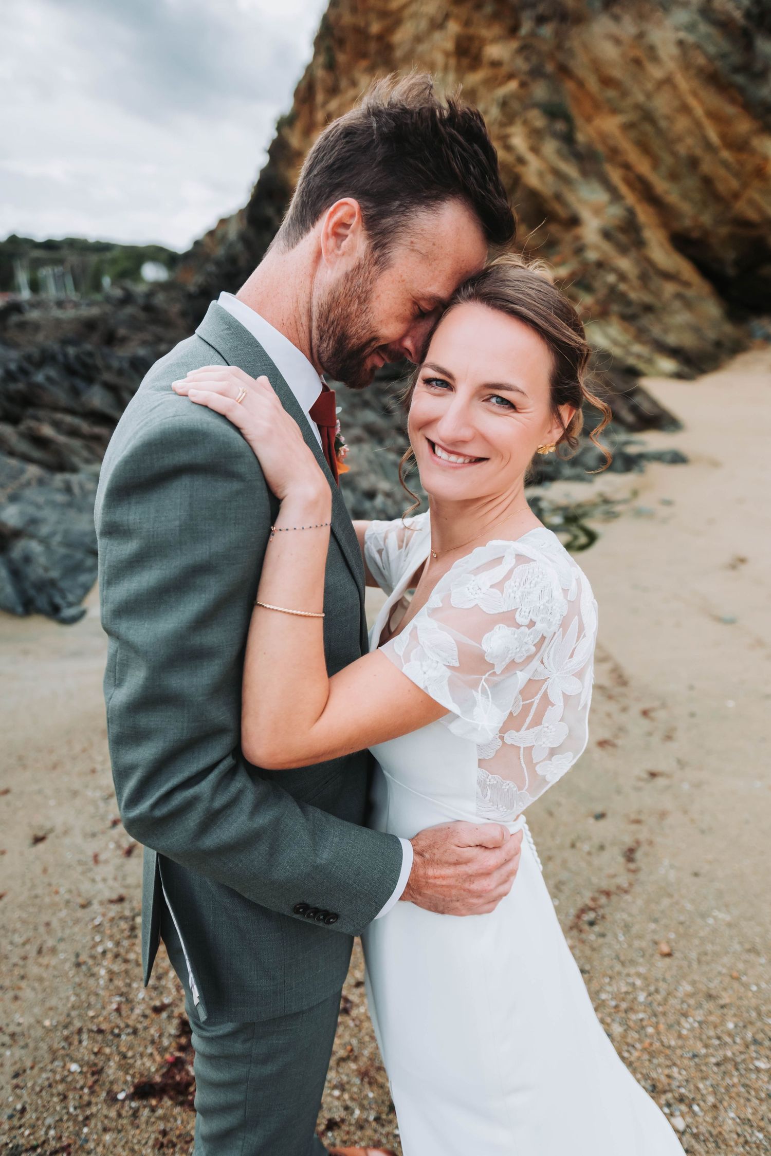 Couple de mariés enlacés sur la plage, séance photo de mariage naturelle en Bretagne