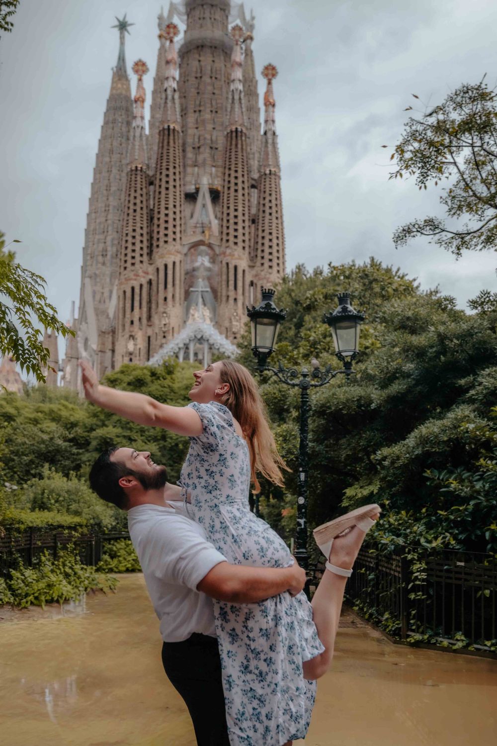 Joyful couple spinning around in the empty space of the park.