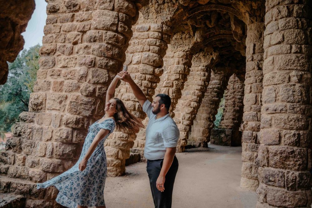 Romantic kiss on the stairs of Park Güell with mosaic background.