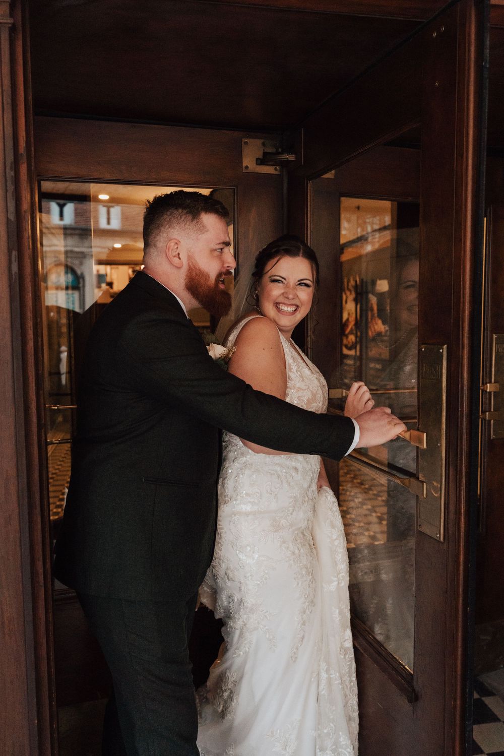 Bride and groom portrait at revolving door of the Yorktowne Hotel  wedding in York PA– elegant winter wedding
