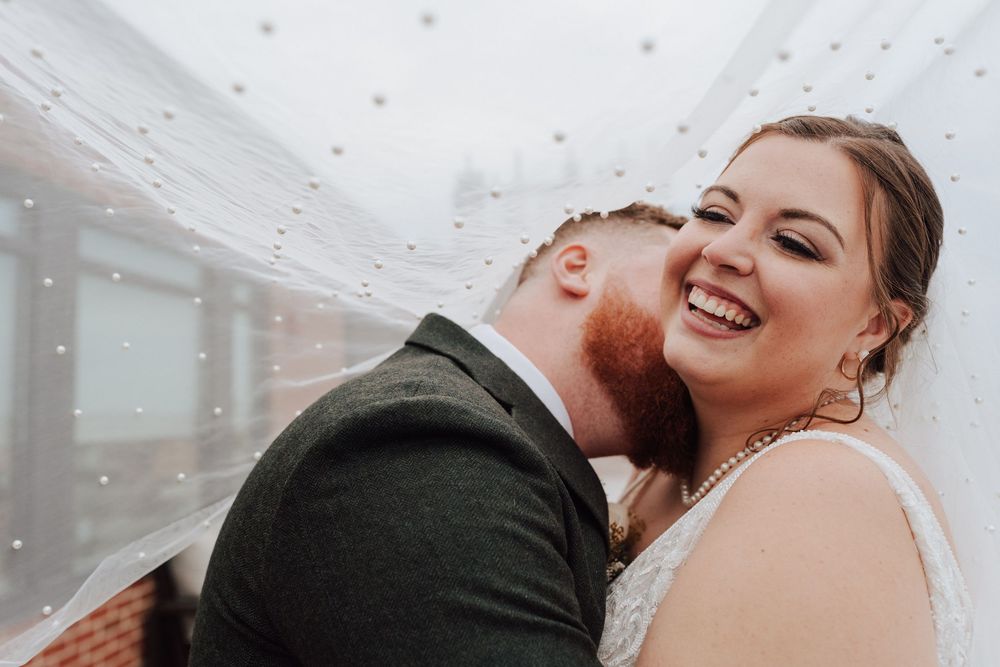 Bride and groom portrait with flowing veil at rooftop of the Yorktowne Hotel  wedding in York PA– elegant winter wedding