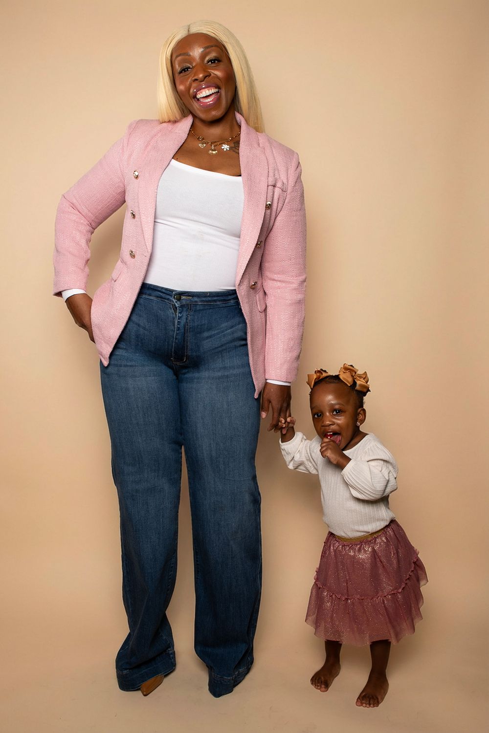 Coordinated pink and white outfits shown against a beige studio backdrop.