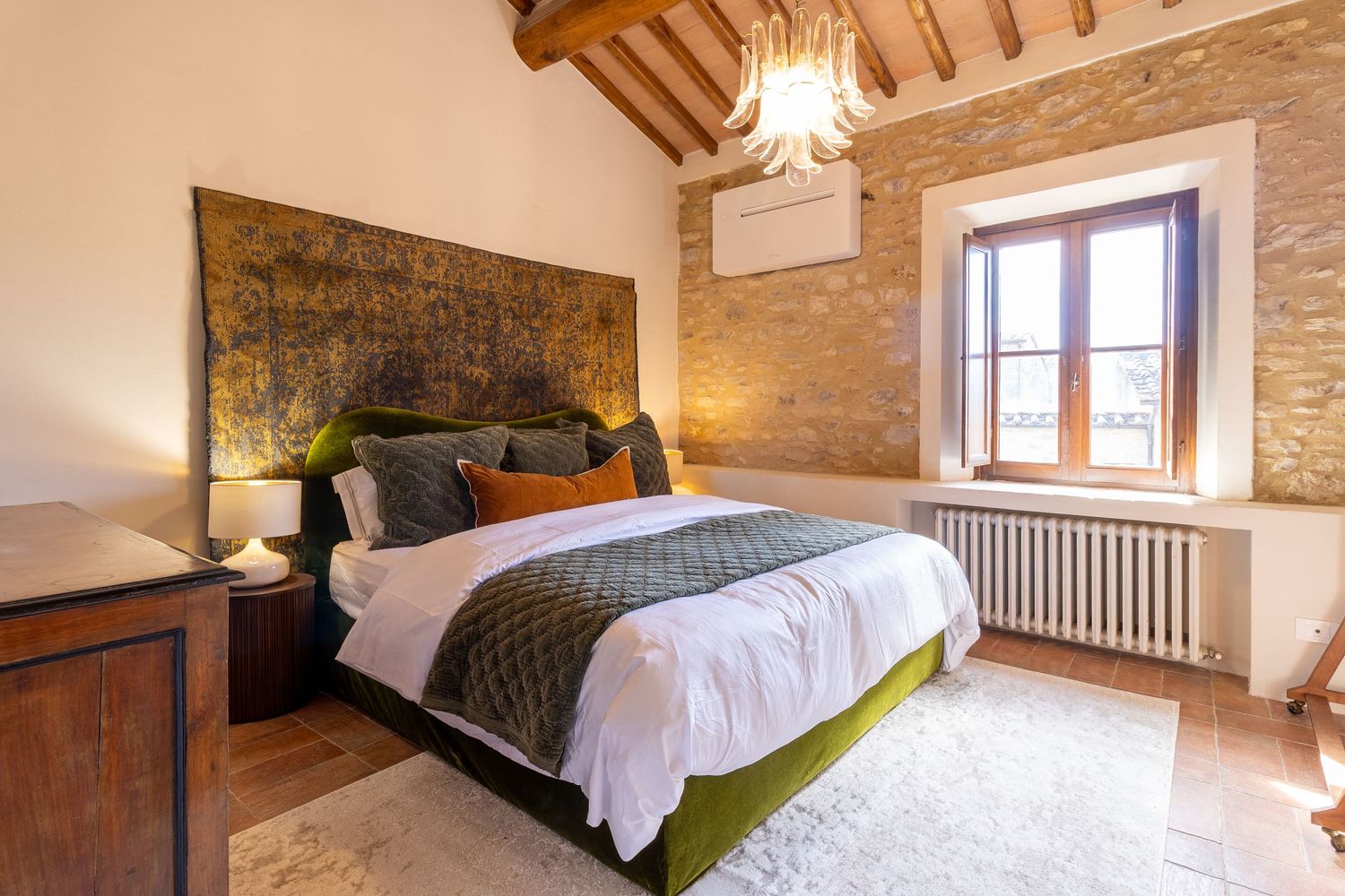 Luxury Airbnb photographer in Florence, Italy. Elegant rustic bedroom with exposed wooden beams, stone walls.