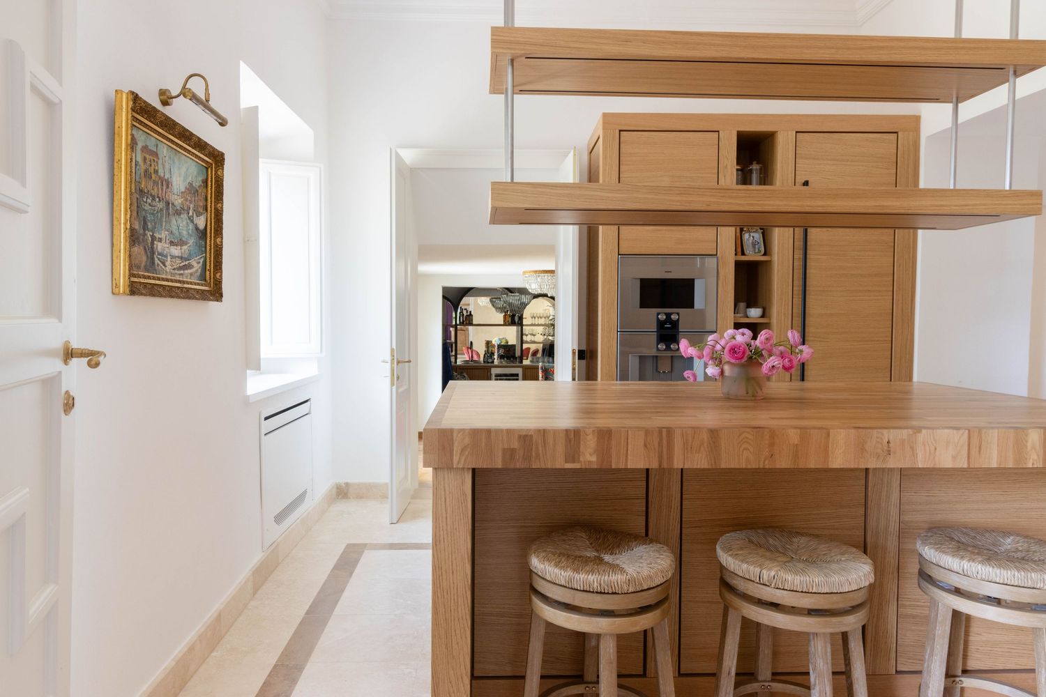 Professional property photographer in Tuscany Italy. Modern white kitchen interior with wood cabinets.