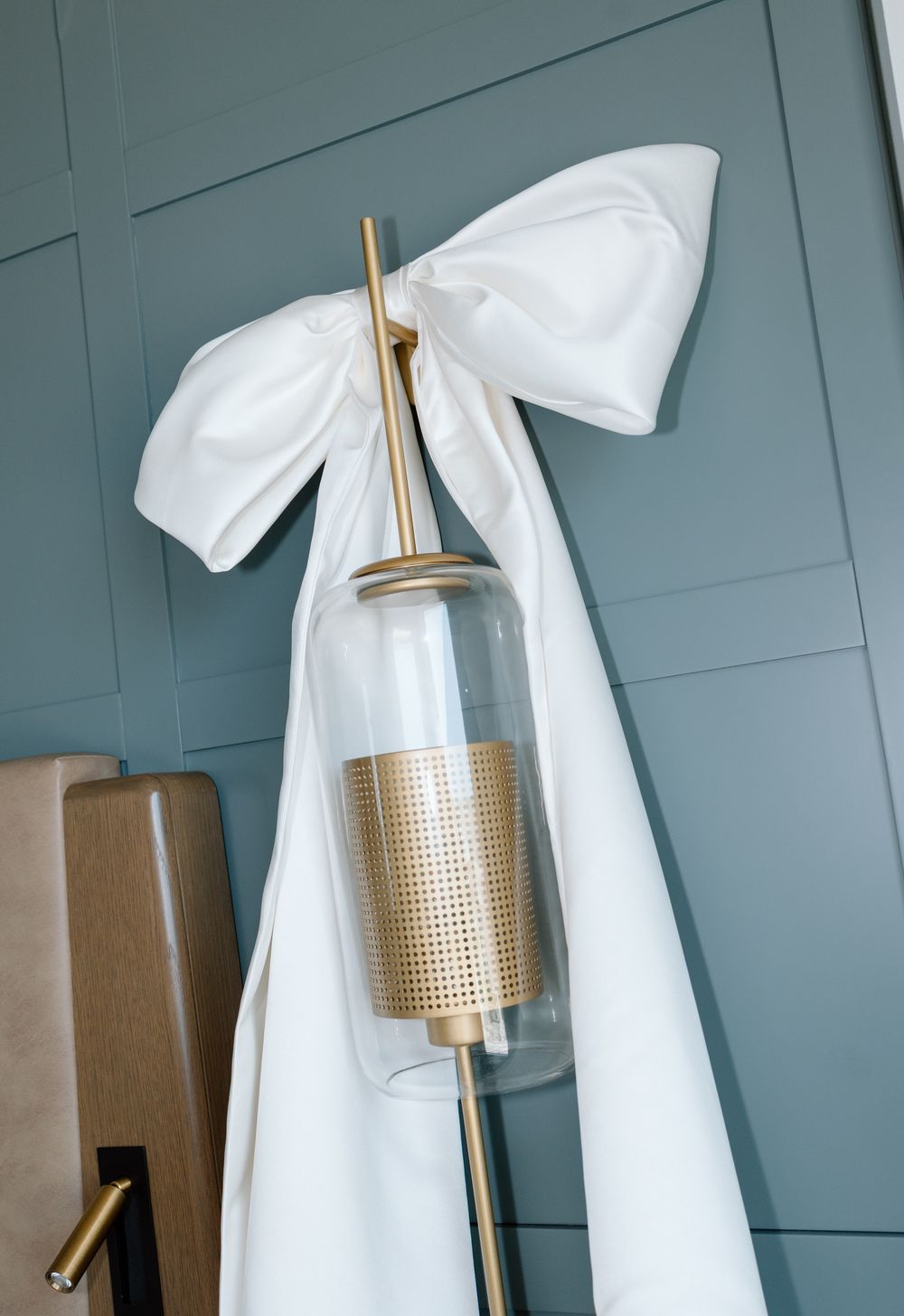 Gold and white bathroom accessories arranged against a blue-gray wall.