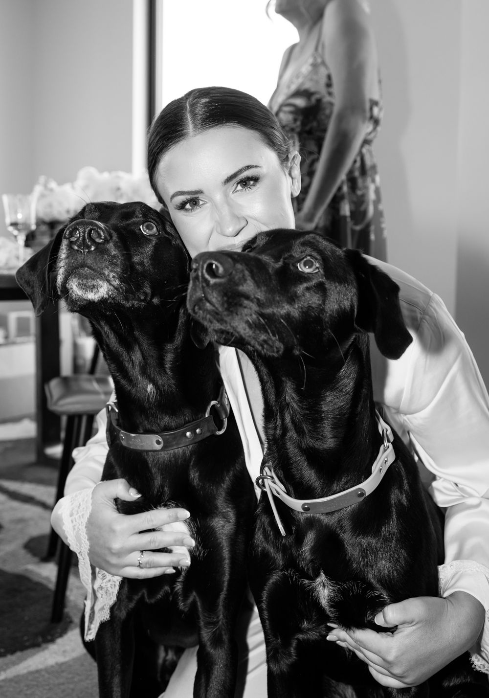 Black Labrador dogs sitting together in a black and white photograph.