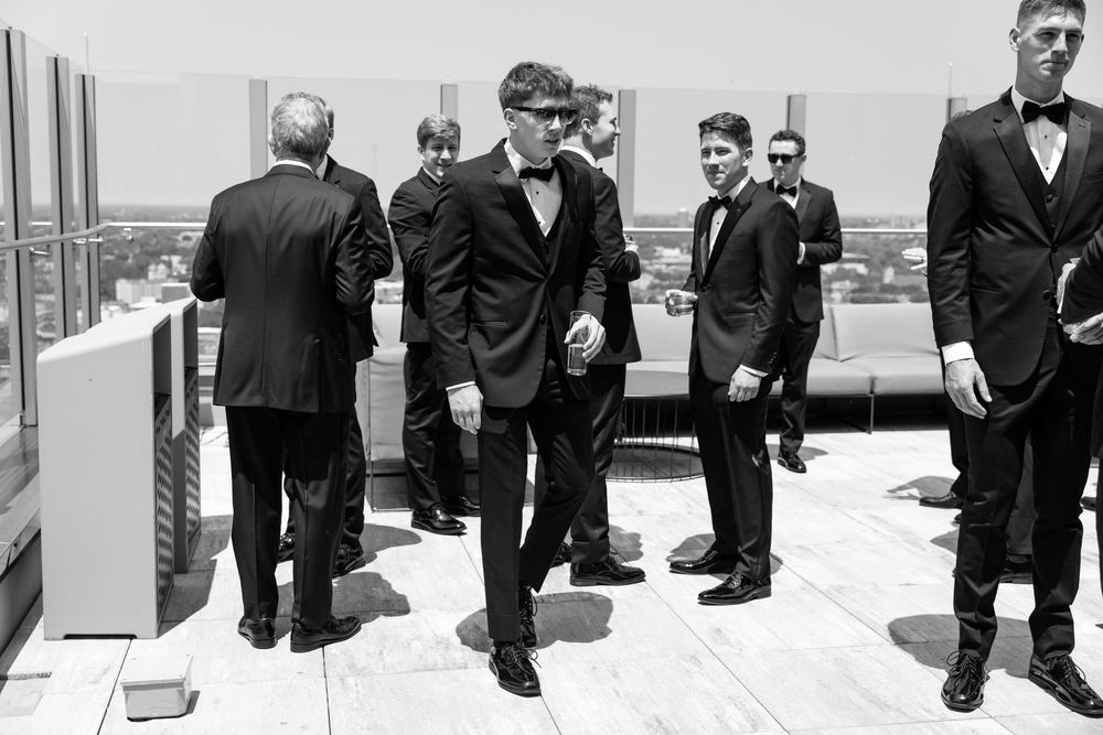Men in formal attire walking in sequence across a room.