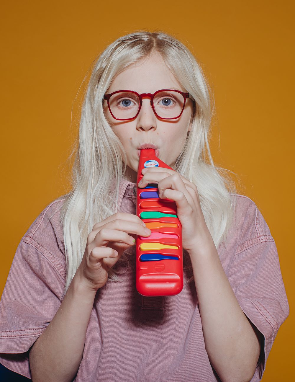 A sequence showing someone drinking from a bright red water bottle against an orange background.