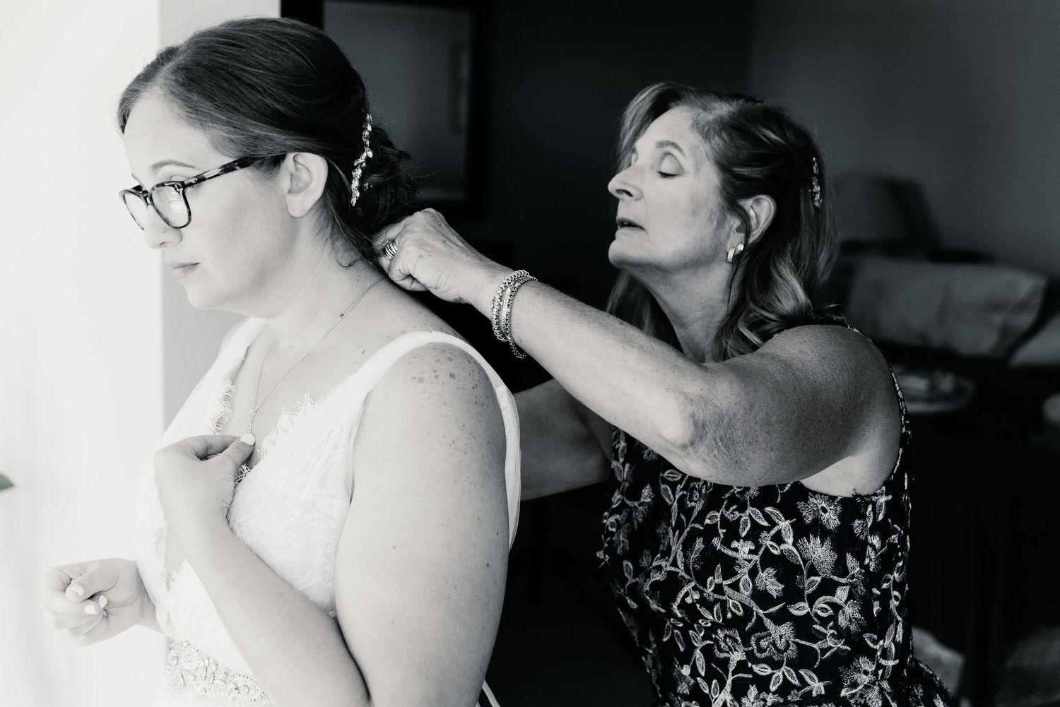 Black and white wedding photos showing tender moments between couples and loved ones during an emotional celebration.