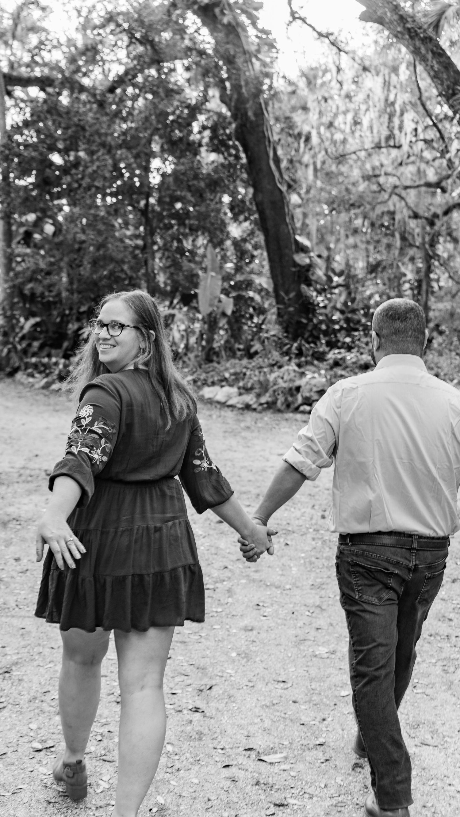 A series of black and white photos showing a couple walking away together through a wooded area.