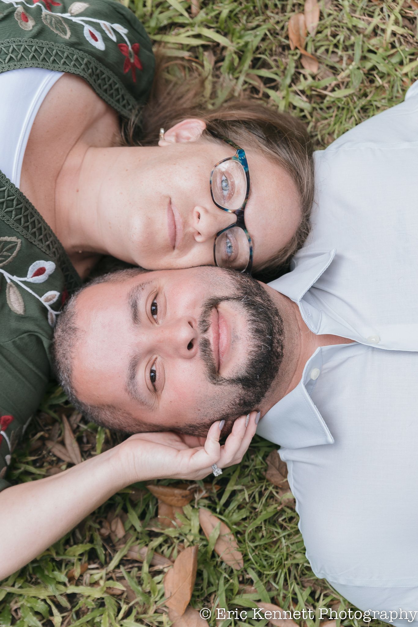 A person in glasses and white shirt lying on grass with fallen leaves creates an artistic portrait series.