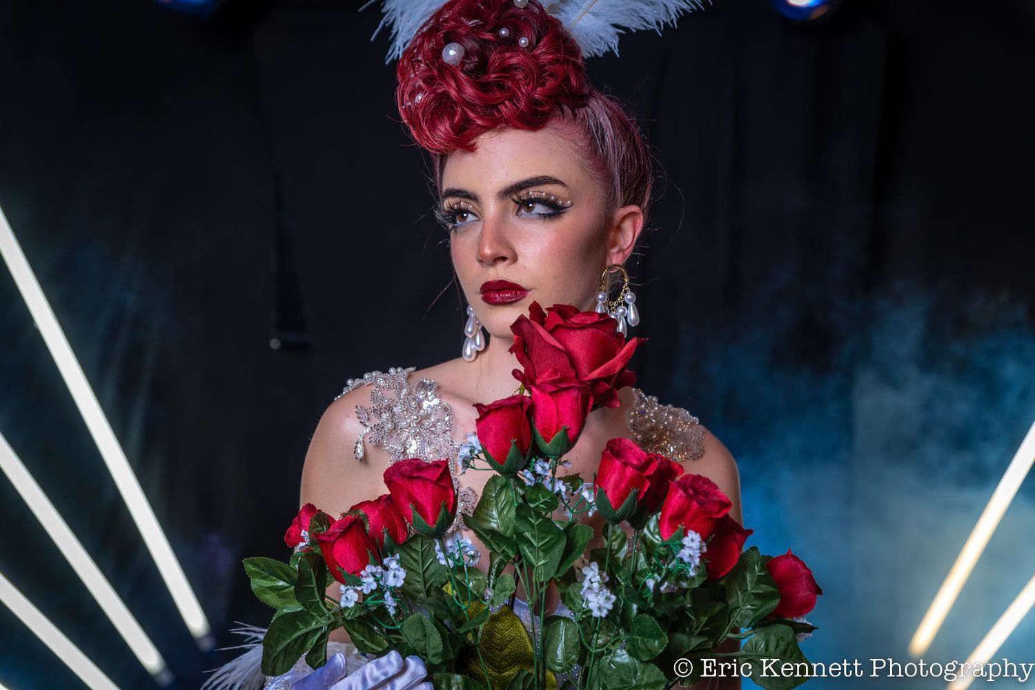 Vintage-styled portrait with red roses and dramatic lighting against dark background with neon accents.