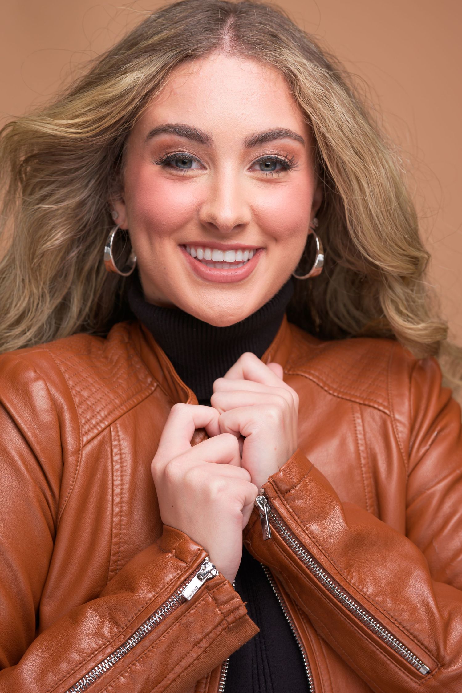 A person in a brown leather jacket smiles while playfully posing in a series of connected headshots.