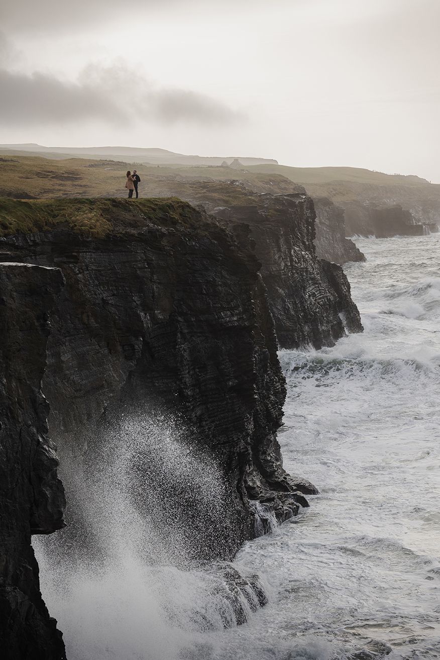Cinematic sunset couple portraits overlooking dramatic coastal cliffs in Ireland