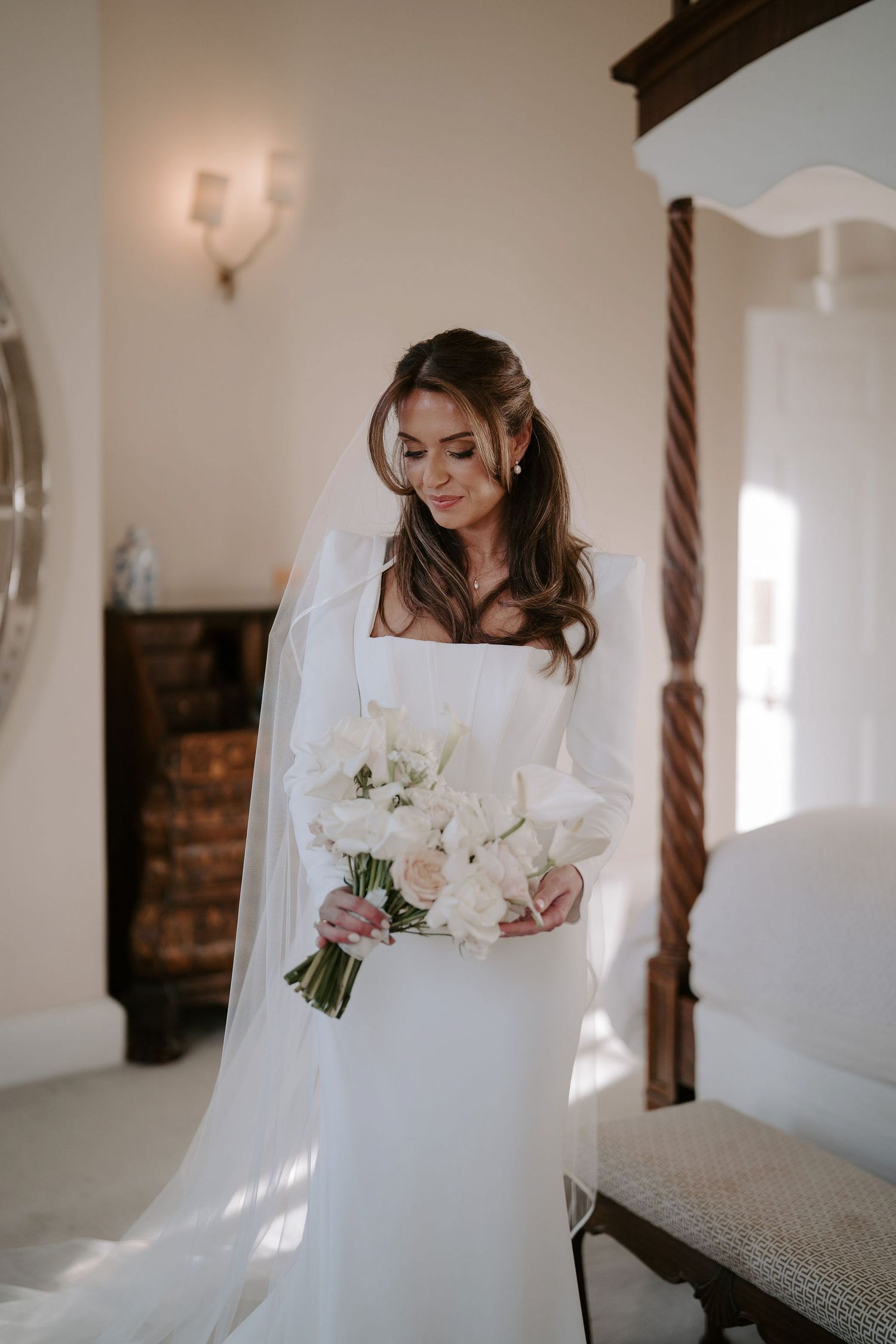 bride looking down at her bouquet smiling before her ceremony at Iscoyd park