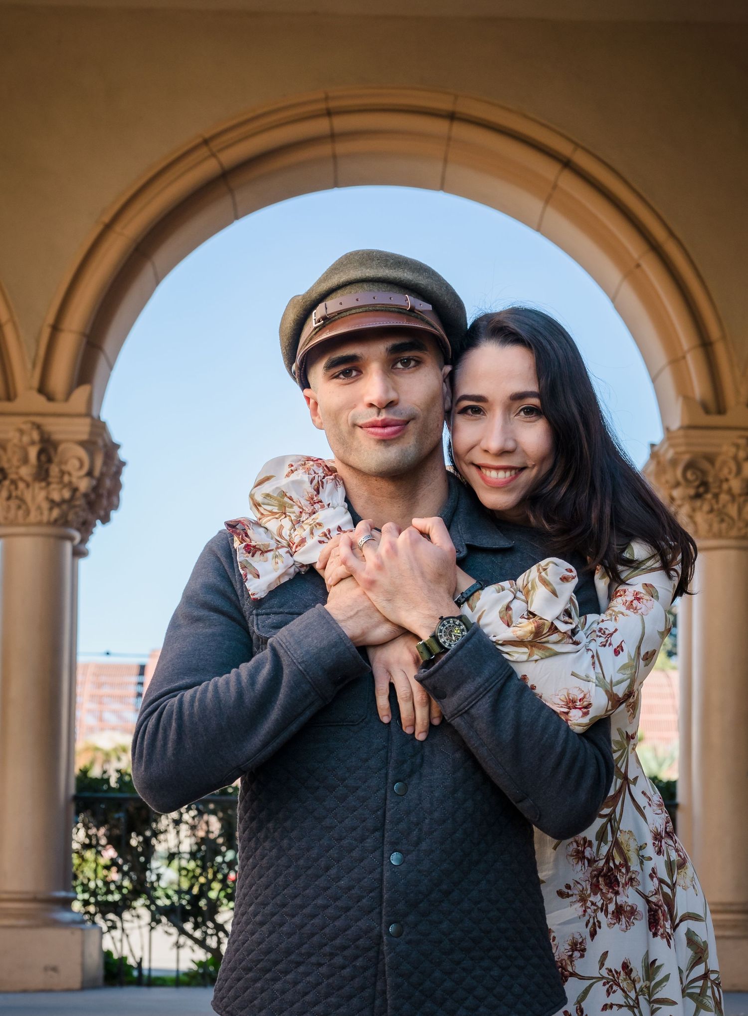 A couple shares romantic moments under stone archways in a series of connected photos.