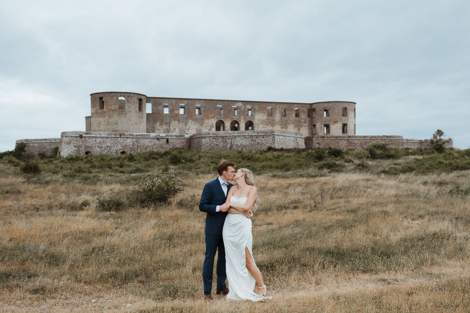 Bröllop på Borgholms slottsruin. Brudpar kramas framför Borgholms slottsruin.