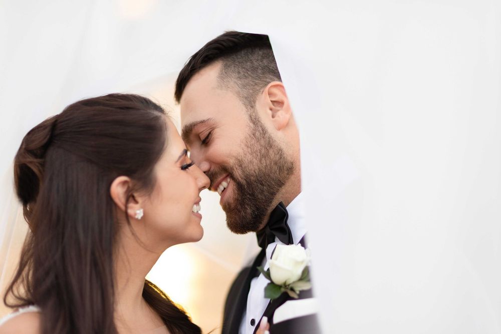 Romantic close-up of smiling bride and groom sharing an intimate moment on their wedding day.