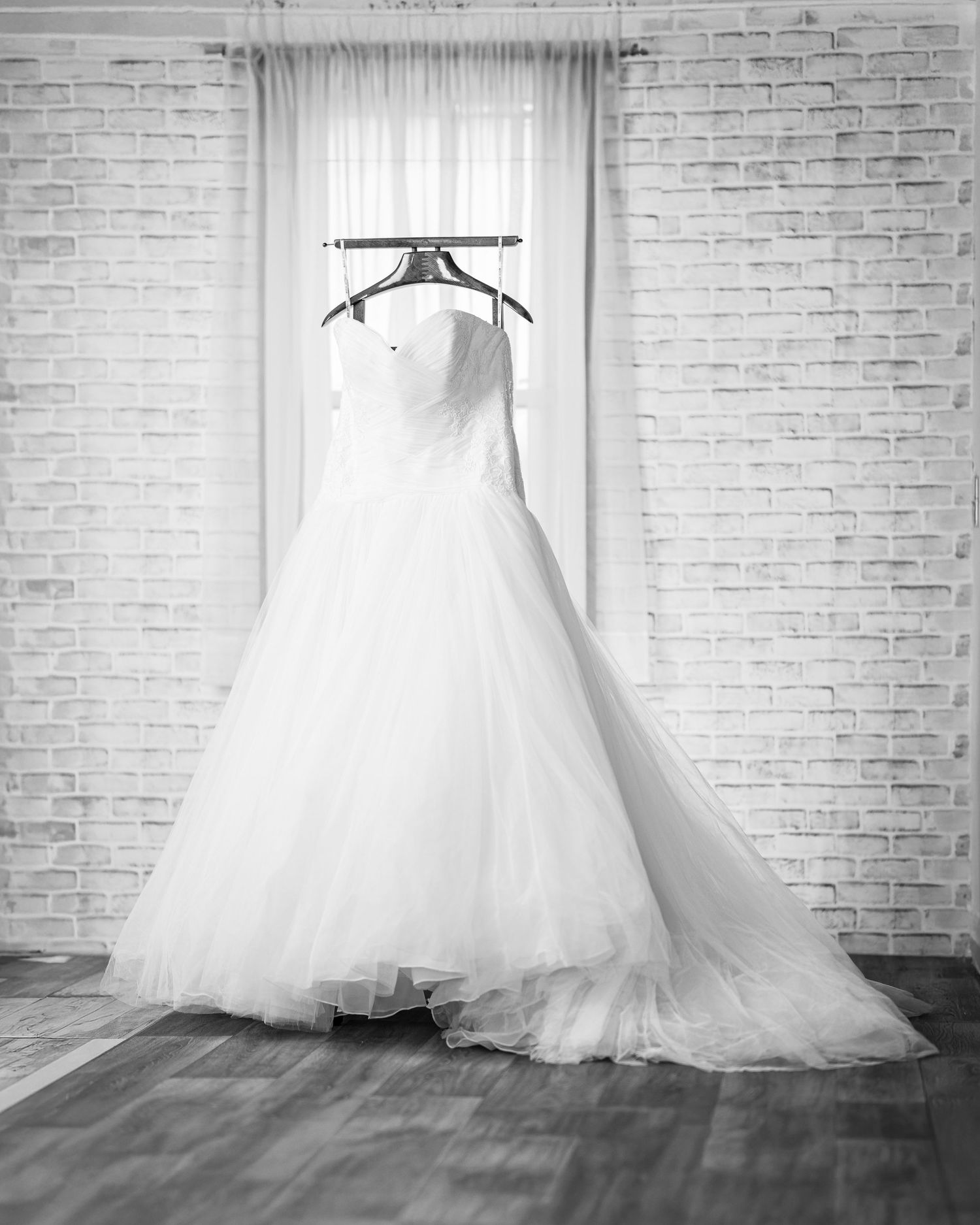 Romantic wedding couple shares a tender kiss under flowing white veil during intimate moment.