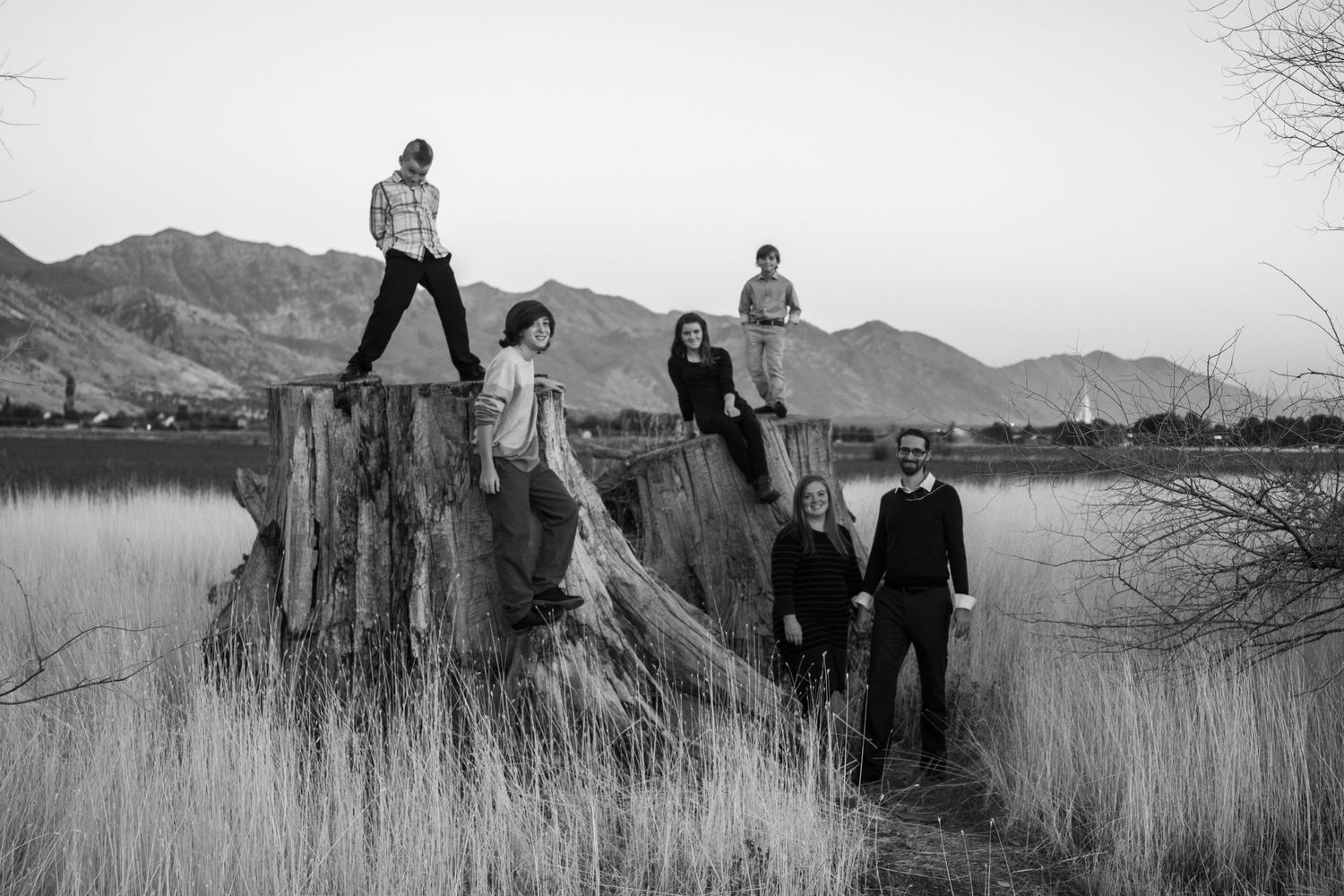 Family of 6 sand dramatically against an Utah mountain landscape.